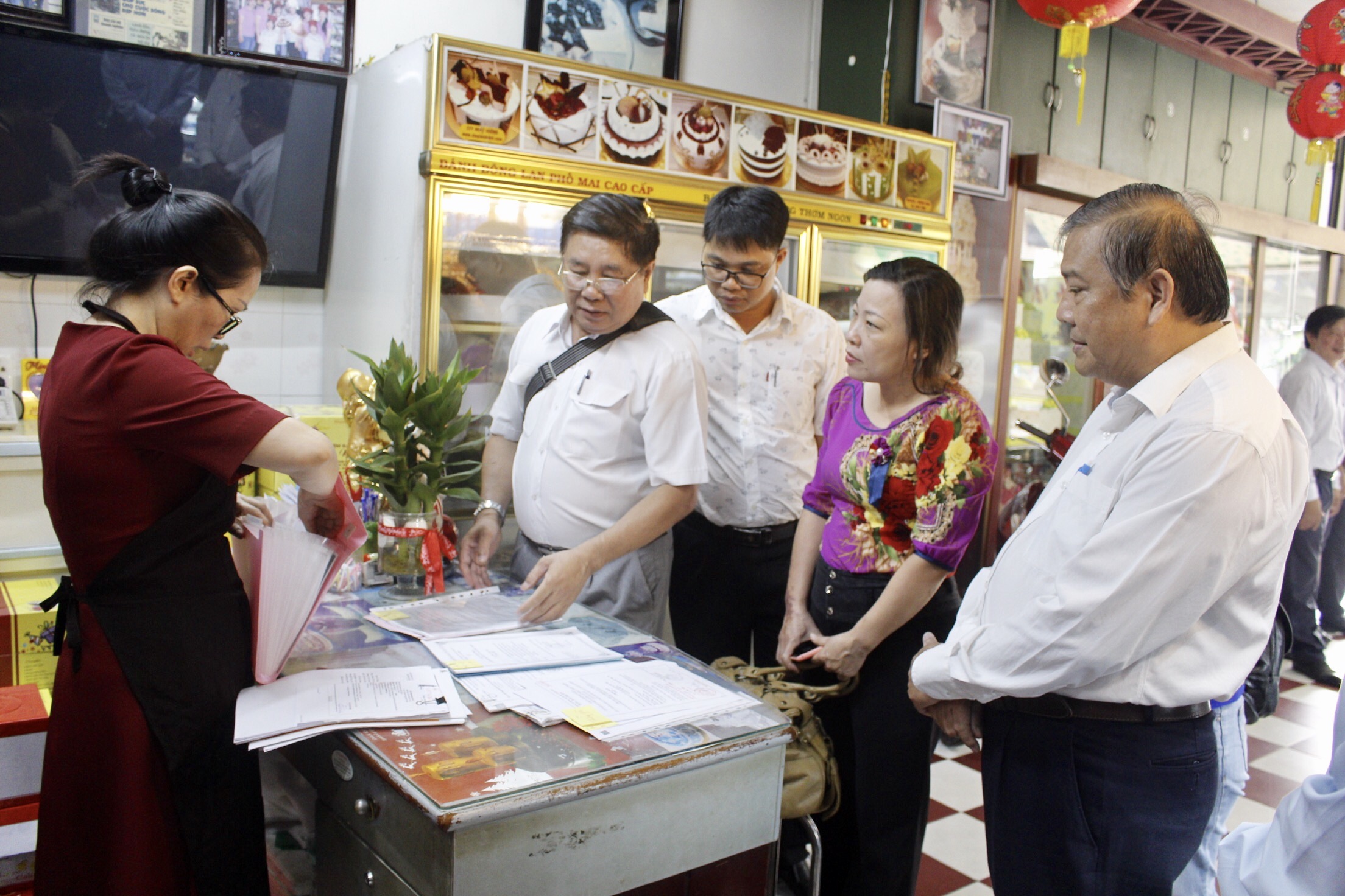 Đồng chí Bùi Thanh Nghĩa, Ủy viên Ban Thường vụ Tỉnh ủy, Chủ tịch UBMTTQVN tỉnh kiểm tra các thủ tục hành chính về đăng ký VSATTP tại hộ kinh doanh Minh Nguyệt.