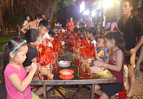 Các em thiếu nhi trang trí lồng đèn Trung thu tại chương trình.