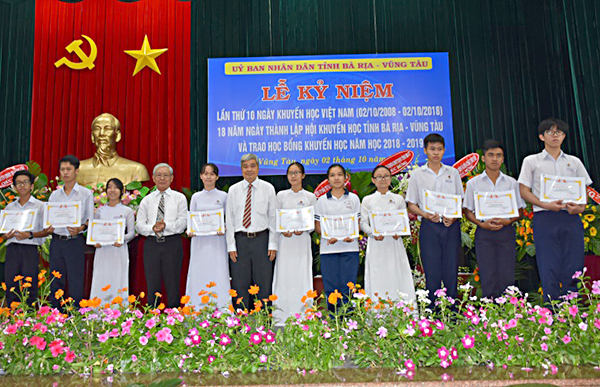 Ông Nguyễn Hồng Tuấn và ông Bùi Xuân Vịnh, đại diện Hội Khuyến học tỉnh trao học bổng cho các em học sinh.