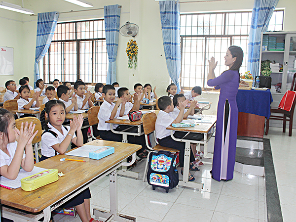 Với học sinh đầu cấp, tốc độ viết của các em tương đối chậm nên việc làm bài vào những phần được biên soạn riêng trong SGK nhằm bảo đảm việc dạy và học. Trong ảnh: Một tiết học của học sinh lớp 1, Trường TH Lý Tự Trọng (TP.Vũng Tàu). 