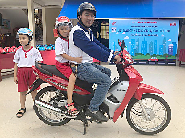 Buổi hướng dẫn HS đội mũ bảo hiểm và ngồi xe máy an toàn tại Trường TH Quang Trung (TP.Vũng Tàu).