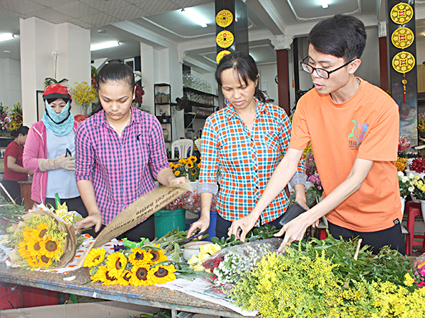 Nhân viên Trung tâm hoa tươi Minh Tâm bó hoa cho khách.