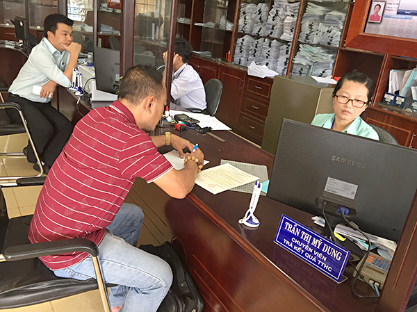 Công chức huyện Đất Đỏ tiếp nhận hồ sơ thủ tục hành chính của người dân tại Bộ phận “một cửa”. Ảnh: HOÀNG HƯỜNG