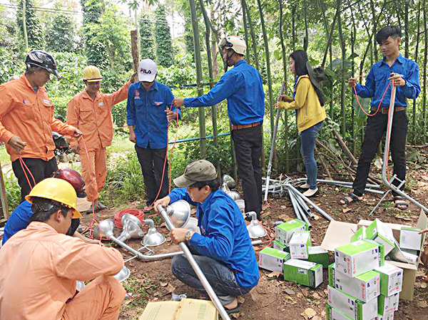 Đoàn viên, thanh niên và người dân chuẩn bị vật tư, thiết bị để lắp đặt hệ thống chiếu sáng trên các tuyến đường ở thôn Hoàng Long, xã Kim Long, huyện Châu Đức.