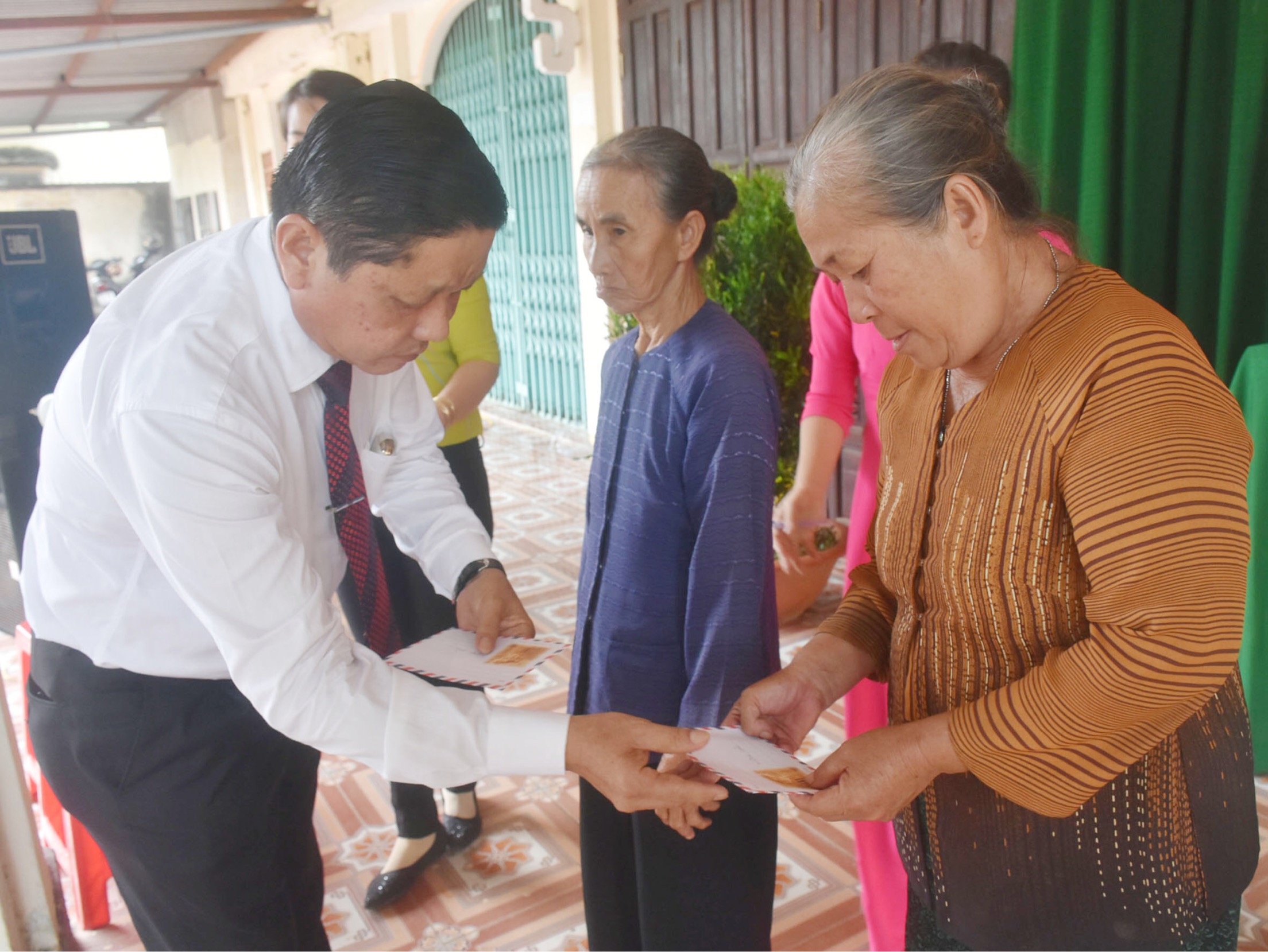Đồng chí Đỗ Văn Bửu, Ủy viên Ban Thường vụ Tỉnh ủy, Chủ nhiệm UBKT Tỉnh ủy tặng quà cho các hộ nghèo tại khu phố Phước Trung, thị trấn Đất Đỏ (huyện Đất Đỏ). Ảnh: TRÍ NHÂN