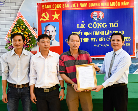 Đồng chí Mai Minh Quang (bìa phải), Bí thư Đảng ủy Khối Doanh nghiệp tỉnh trao quyết định thành lập Chi bộ cơ sở Công ty TNHH MTV kết cấu thép PEB.