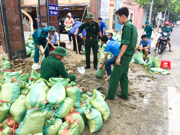 Bộ đội Biên phòng cẩn thận đóng từng bao cát, giúp dân chằng, chống nhà cửa.