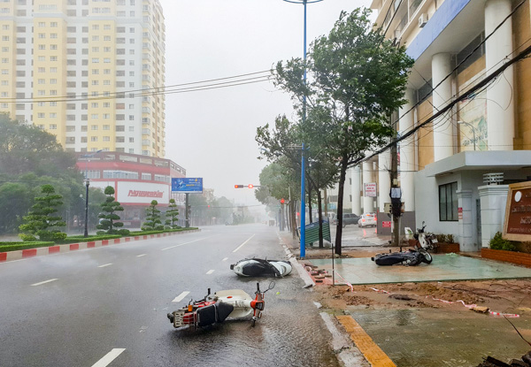 Các phương tiện xe máy lưu thông trên đường gặp gió to đổ ngã trên đường Lê Hồng Phong (TP. Vũng Tàu) sáng 25-11. Ảnh: MẠNH THẮNG