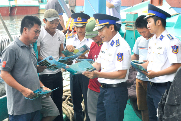 Đại diện Bộ Tư lệnh Vùng CSB 3 phát tờ rơi tuyên truyền pháp luật cho ngư dân tại cảng cá Cát Lở (TP. Vũng Tàu).