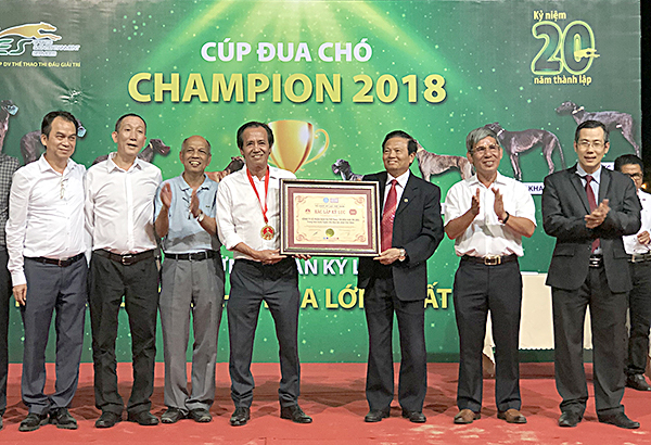 Đại diện Tổ chức Kỷ lục Việt Nam trao chứng nhận xác lập kỷ lục Trung tâm huấn luyện chó đua lớn nhất Việt Nam cho ông Nguyễn Ngọc Mỹ, Tổng Giám đốc SES.