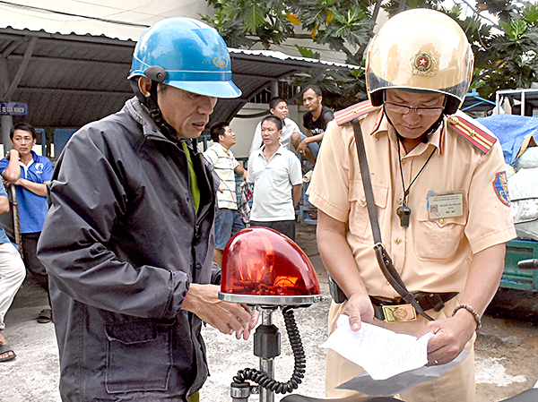 CSGT Công an TP.Vũng Tàu lập biên bản xử lý người điều khiển xe 3 bánh vi phạm Luật giao thông đường bộ. Ảnh: PHƯƠNG NAM