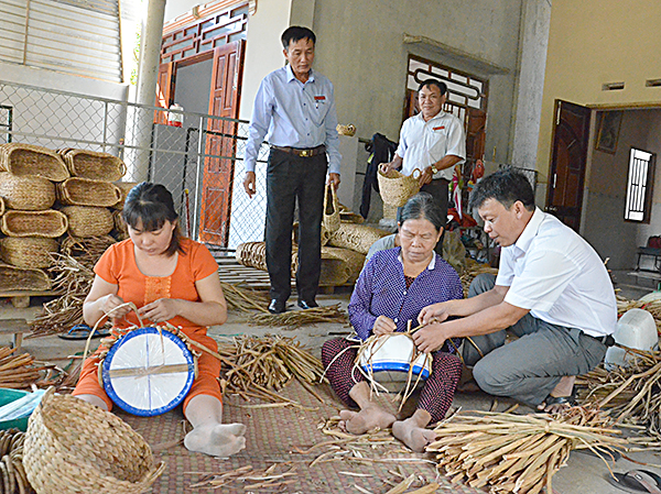 Hội viên CCB Cao Quang Tình (bìa phải), hướng dẫn người dân cách đan giỏ lục bình để cải thiện thu nhập.