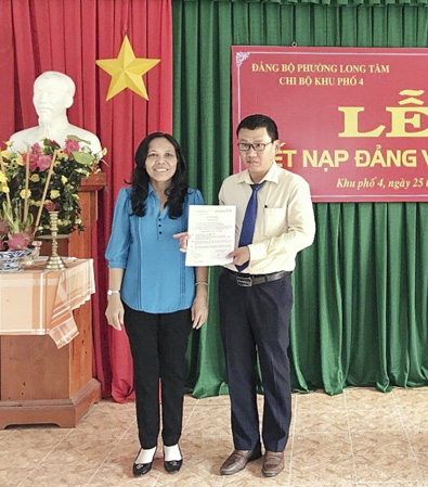 Đồng chí Trương Thị Lệ Hằng, Phó Bí thư Thường trực Đảng ủy phường Long Tâm (TP.Bà Rịa) trao quyết định kết nạp đảng cho ông Lương Văn, Phó Giám đốc Công ty TNHH Thiết kế và xây dựng Nam Long.  Ảnh: NGUYỄN PHƯỚC