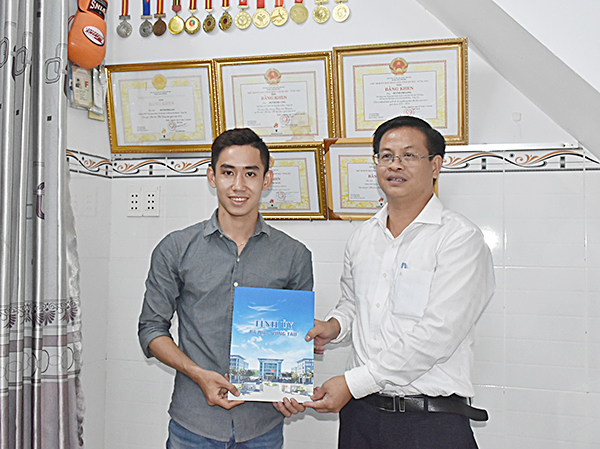 Đại diện lãnh đạo Văn phòng Tỉnh ủy trao tiền hỗ trợ cho VĐV Phi Long.