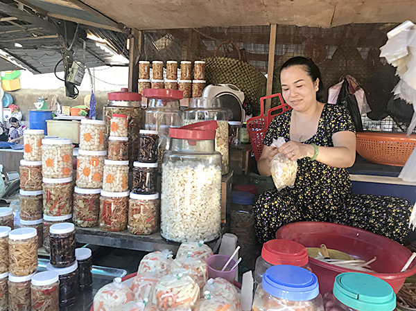 Chị Nguyễn Thị Thảo, tiểu thương bán kiệu, hành tại chợ phường 1, TP. Vũng Tàu đóng gói củ kiệu giao cho khách.