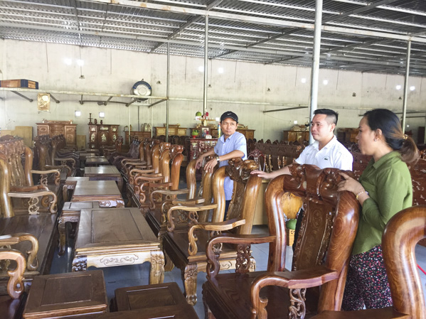 Chị Dương Thị Kim Linh, chủ cơ sở sản xuất, phân phối gỗ Vạn Phúc giới thiệu các sản phẩm gỗ của gia đình cho khách hàng.