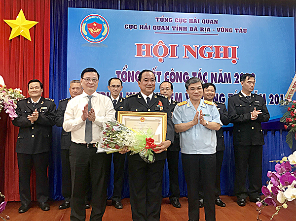 Đồng chí Nguyễn Thành Long, Phó Chủ tịch UBND tỉnh thừa ủy quyền của Chủ tịch nước trao tặng Huân chương Chiến công hạng Nhất cho ông Trần Văn Danh, Cục trưởng Cục Hải quan tỉnh.