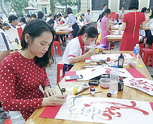 Giáo viên và HS Trường THCS Nguyễn An Ninh viết thư pháp tại Hội thi.