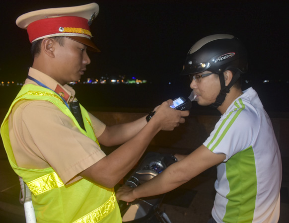 Lực lượng CSGT kiểm tra nồng độ cồn một người điều khiển xe máy.