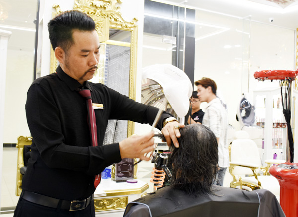 Anh Nguyễn Trung Kỳ, chủ Viện tóc Hiệp Kỳ tạo mẫu tóc cho khách tại chi nhánh chung cư DIC Phoenix. 