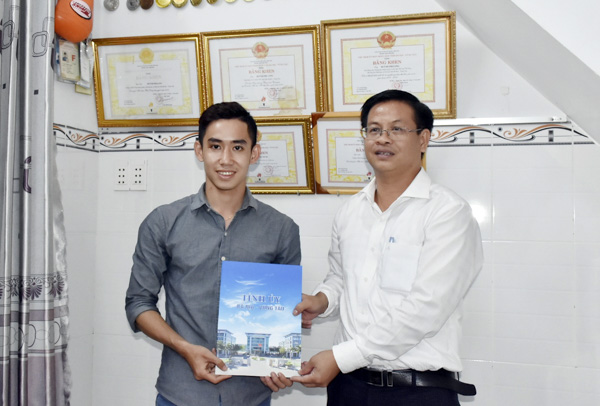 Đại diện Văn phòng Tỉnh ủy trao tiền hỗ trợ cho VĐV Phi Long. 