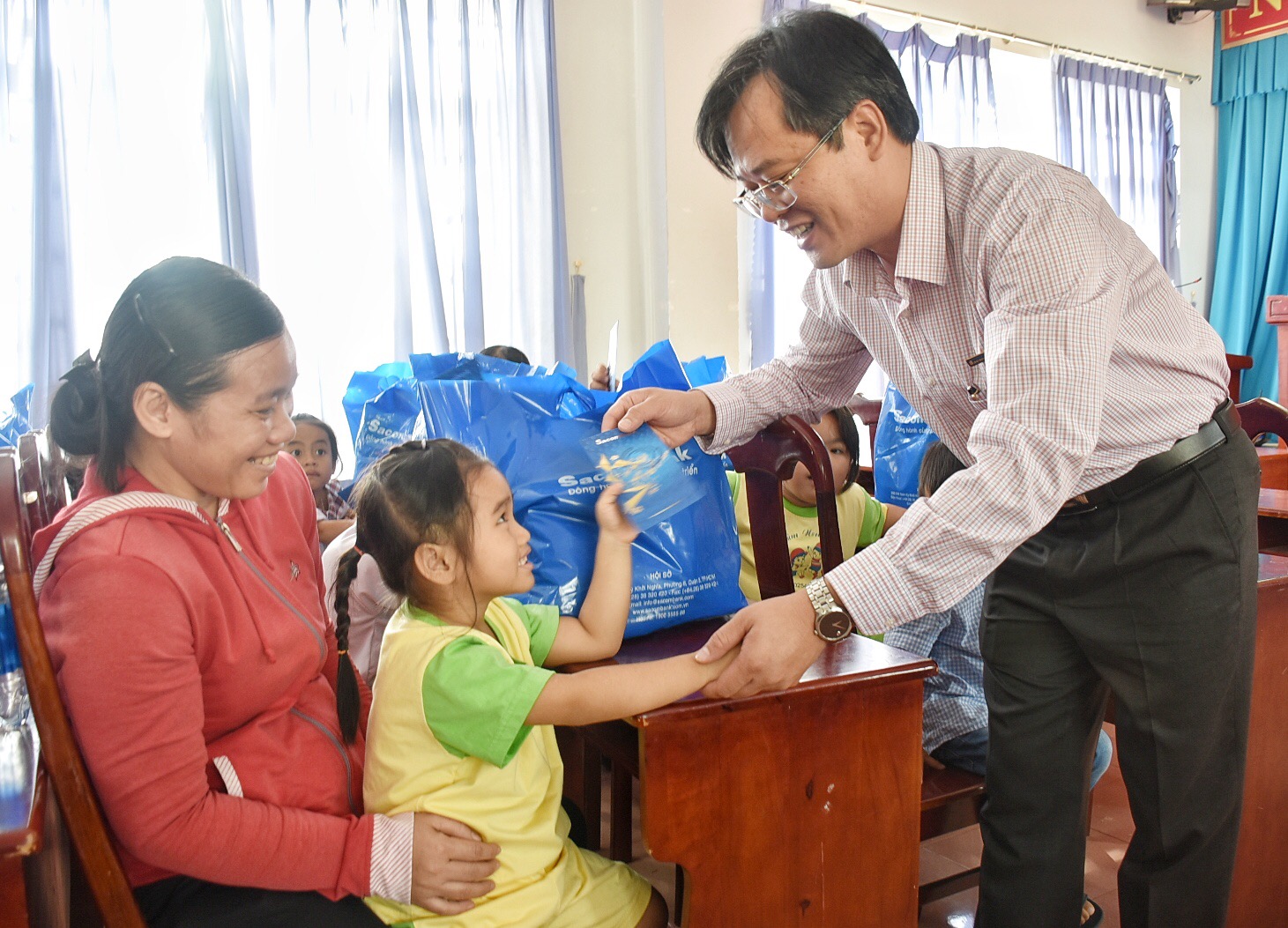 Ông Trần Quốc Khang, Giám đốc Ngân hàng Sacombank Chi nhánh Bà Rịa trao quà cho HS có hoàn cảnh khó khăn trên địa bàn huyện Đất Đỏ.