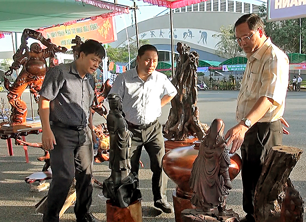 Ông Nguyễn Tấn Bản (bìa trái), Phó Chủ tịch UBND huyện Châu Đức tham quan gian hàng triễn lãm đồ gỗ của xã Quảng Thành.