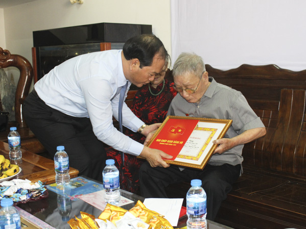 Đồng chí Mai Ngọc Thuận, Ủy viên Ban Thường vụ Tỉnh ủy, Bí thư Thành ủy Vũng Tàu, Chủ tịch HĐND thành phố trao Huy hiệu 70 năm tuổi Đảng cho đồng chí Dương Quang Trung.