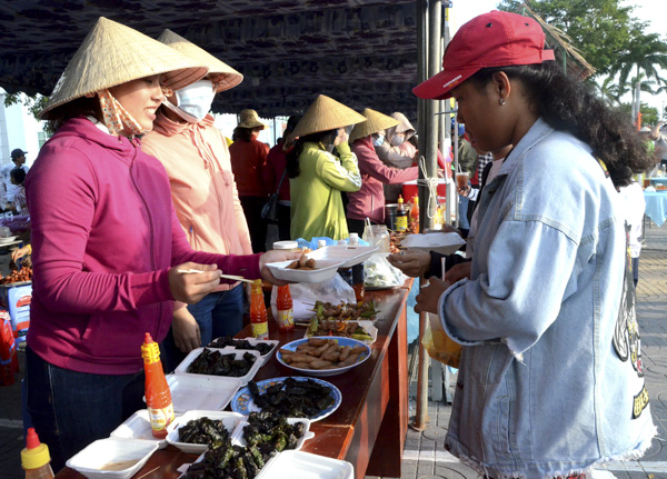 Người dân và du khách thưởng thức các món ăn trong hội vui Xuân tổ chức tại Trung tâm Văn hóa - Thể thao huyện.