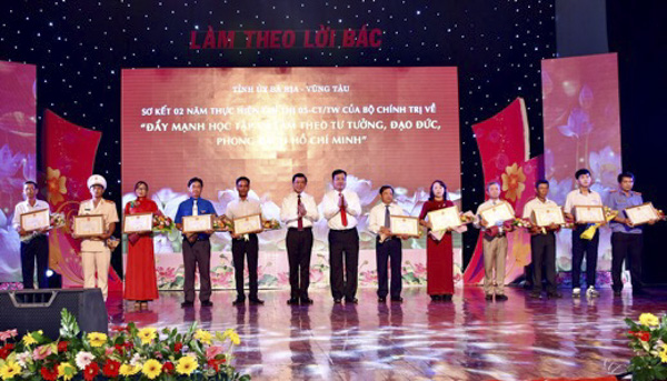 Đồng chí Nguyễn Hồng Lĩnh, Ủy viên Trung ương Đảng, Bí thư Tỉnh ủy, Chủ tịch HĐND tỉnh và đồng chí Nguyễn Văn Trình, Phó Bí thư Tỉnh ủy, Chủ tịch UBND tỉnh tặng Bằng khen của UBND tỉnh cho các tập thể và cá nhân điển hình tại Chương trình sơ kết 2 năm thực hiện Chỉ thị 05-CT/TW của Bộ Chính trị (khóa XII) về “Đẩy mạnh học tập và làm theo tư tưởng, đạo đức, phong cách Hồ Chí Minh”. Ảnh: LƯU THẮNG