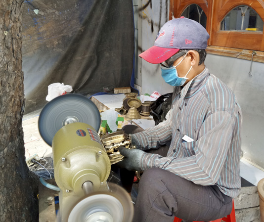 Ông Nguyễn Thành Nam đánh bóng lư đồng cho khách. 
