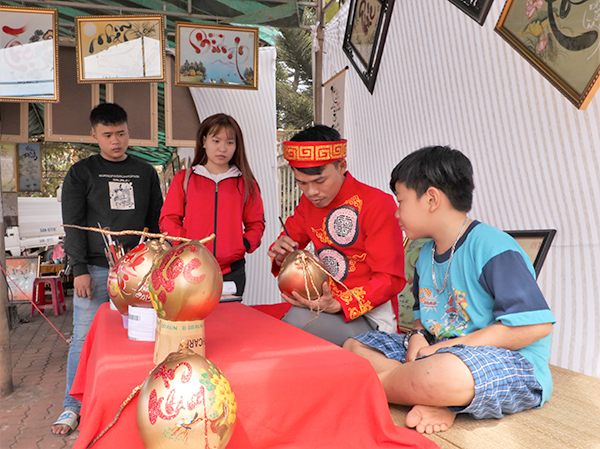 “Ông Đồ” Đăng Quang thể hiện nét chữ bay lượn của mình trên những quả dừa chưng Tết.