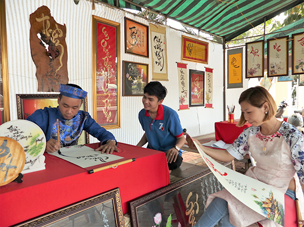 “Ông Đồ” Phạm Nguyễn viết chữ đầu xuân cho khách.