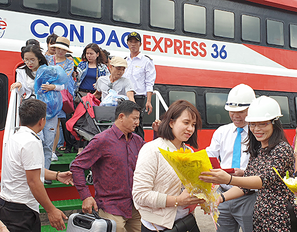 Bà Nguyễn Thị Thu Thảo, Trưởng Phòng VH-TT huyện Côn Đảo tặng hoa cho những vị khách đầu tiên từ tàu Côn Đảo Express 36. Ảnh: THÁI THỦY