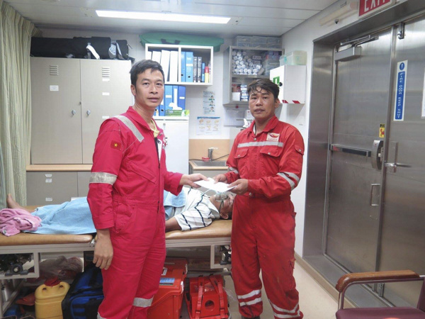 Giàn trưởng Tống Đình Thiên Phú trao tiền hỗ trợ của công đoàn giàn cho người thân đi cùng nạn nhân trước khi chuyển về bờ.