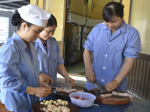 Chị Hoàng Thị Hồng, công nhân viên quốc phòng Hải đoàn 129 (Bìa trái) cùng đồng nghiệp chuẩn bị bữa trưa cho cán bộ, chiến sĩ, nhân viên của đơn vị.