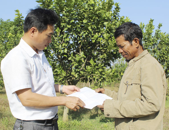Ông Đào Văn Dương (bìa phải, người dân tộc Châu Ro) trao đổi với cán bộ xã Đá Bạc, huyện Châu Đức về công tác phát triển đảng viên ở Chi bộ thôn Lồ Ồ.