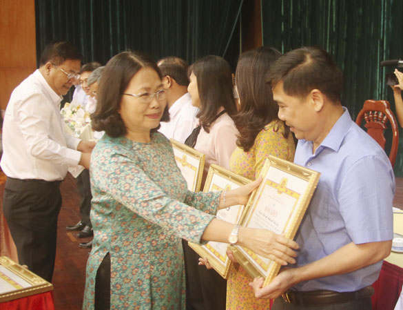 Các đồng chí: Nguyễn Thị Yến, Phó Bí thư Thường trực Tỉnh ủy; Nguyễn Văn Trình, Phó Bí thư Tỉnh ủy, Chủ tịch UBND tỉnh, tặng Bằng khen cho các tập thể đạt thành tích tiêu biểu trong việc thực hiện Nghị quyết 39-NQ/TW giai đoạn 2015-2018 về tinh giản biên chế. Ảnh: TƯỜNG NGÂN