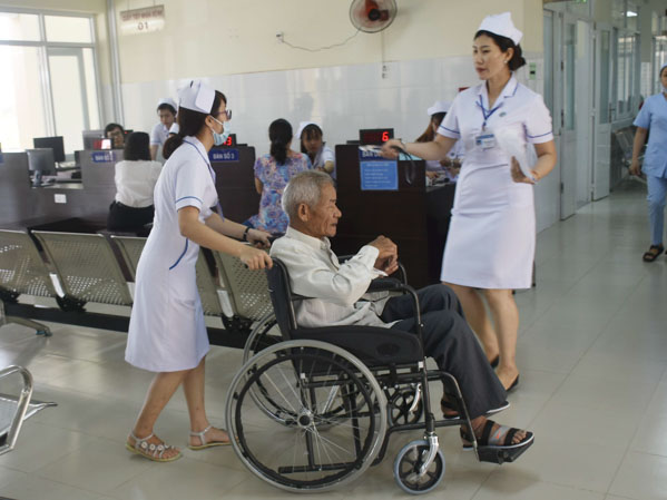 Đảng bộ Sở Y tế xây dựng người cán bộ y tế thái độ phục vụ văn minh, thân thiện. Trong ảnh: Nhân viên y tế hỗ trợ bệnh nhân cao tuổi đi lại khó khăn đến khám chữa bệnh tại Bệnh viện Y học Cổ truyền tỉnh.