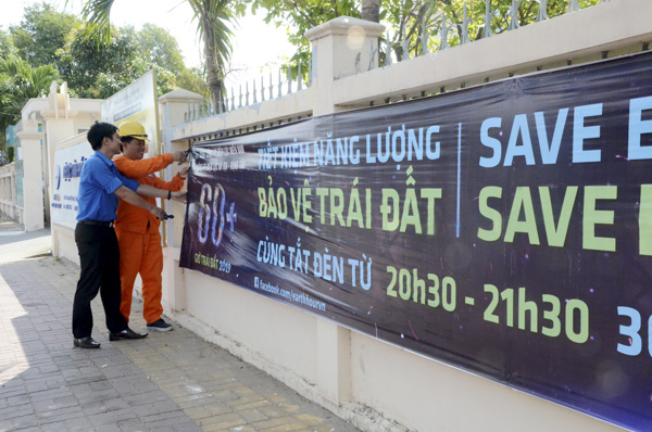 Nhân viên Điện lực Vũng Tàu treo băng rôn tuyên truyền Giờ Trái đất 2019.
