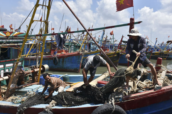 Đa số chủ tàu phải ứng tiền lương trước cho bạn ghe. Trong ảnh: Lao động làm việc tại cảng cá Phước Tỉnh. Ảnh: QUANG VINH
