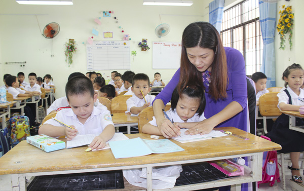 Tình trạng thiếu giáo viên là một khó khăn cần sớm được khắc phục. Trong ảnh: Cô Trần Thị Hồng Liên, GV chủ nhiệm lớp 1A1 Trường TH Lý Tự Trọng (TP.Vũng Tàu) hướng dẫn HS tập viết. Ảnh: KHÁNH CHI