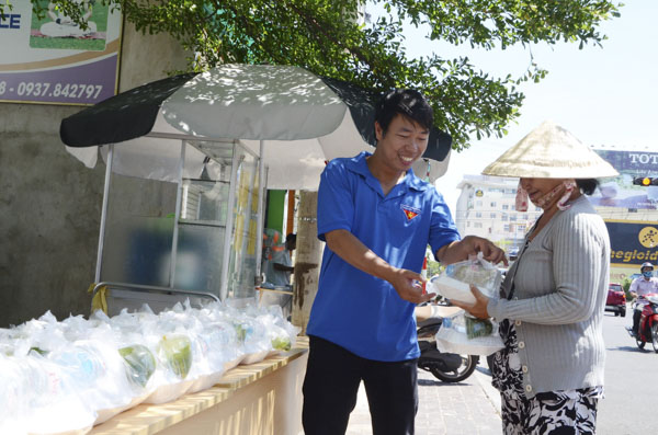 Anh Đoàn Mạnh Thành, Bí thư Đoàn phường 3 phát cơm cho bà Lưu Thị Lệ.