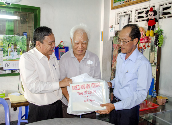 Các đồng chí: Nguyễn Đăng Minh, Phó Bí thư Thường trực Thành ủy Vũng Tàu; Huỳnh Quang Vinh, Chủ tịch Ủy ban MTTQVN TP.Vũng Tàu thăm hỏi, tặng quà ông Hàn Văn Kỳ, người tham gia hoạt động kháng chiến (ở số 176/10/9, Trương Công Định, phường 3, TP.Vũng Tàu). Ảnh: BẢO KHÁNH