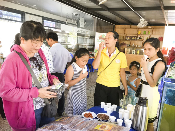 Khách hàng dùng thử một số món ăn và nước trà đậu đen xanh lòng của Công ty TNHH Mộc Thanh Trà Việt Nam.