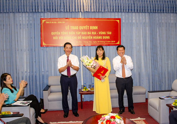 Các đồng chí: Lưu Tài Đoàn, Ủy viên Ban Thường vụ, Trưởng Ban Tổ chức Tỉnh ủy; Nguyễn Văn Xinh, Ủy viên Ban Thường vụ Tỉnh ủy, Trưởng Ban Tuyên giáo Tỉnh ủy trao Quyết định và tặng hoa chúc mừng nhà báo Đỗ Nguyễn Hoàng Dung.