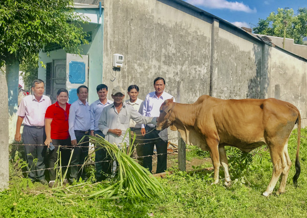 Ông Nguyễn Tấn Bản, Phó Chủ tịch UBND huyện Châu Đức cùng nhà tài trợ và đại diện Hội Chữ thập đỏ huyện trao tặng bò giống cho gia đình ông Huỳnh Cúc (thứ 3 từ phải qua). 