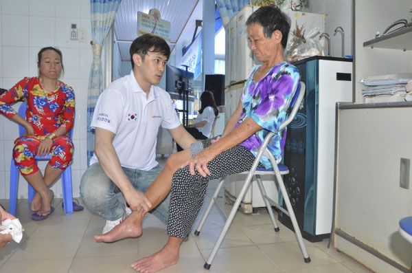 Bác sĩ Kim Byeon Min, thành viên của đoàn, khám bệnh cho bà Phạm Thị Hồng.