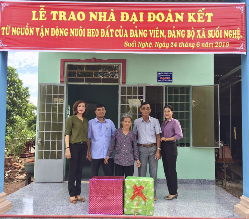 Đại diện xã Suối nghệ trao nhà “đại đoàn kết” cho bà Hoàng Thị Nuôi. 