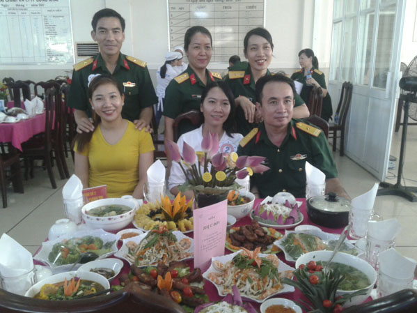 Các món ăn đa dạng, hấp dẫn và bình hoa nhỏ trang trí tại bàn ăn.